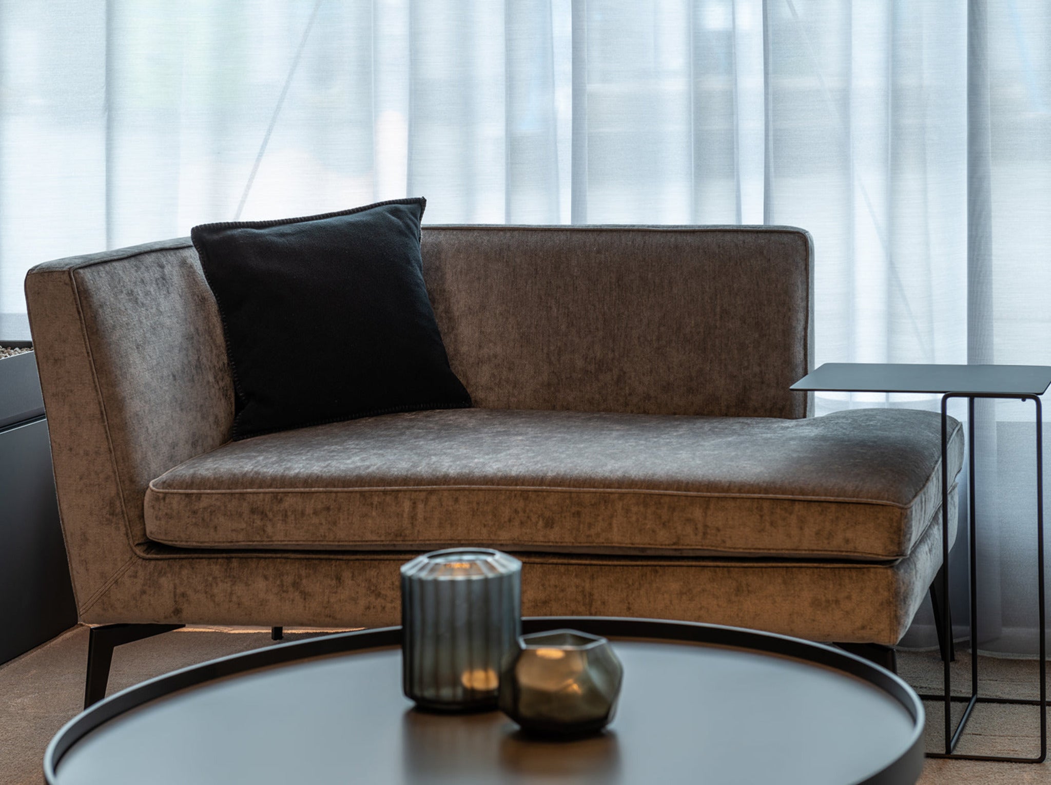 Sitzecke mit Recammiere Kay von Christine Kröncke aus Samt, dazu Couchtisch Cross und Beistelltisch Oki von Walter Knoll. Dekoration von Guaxs.